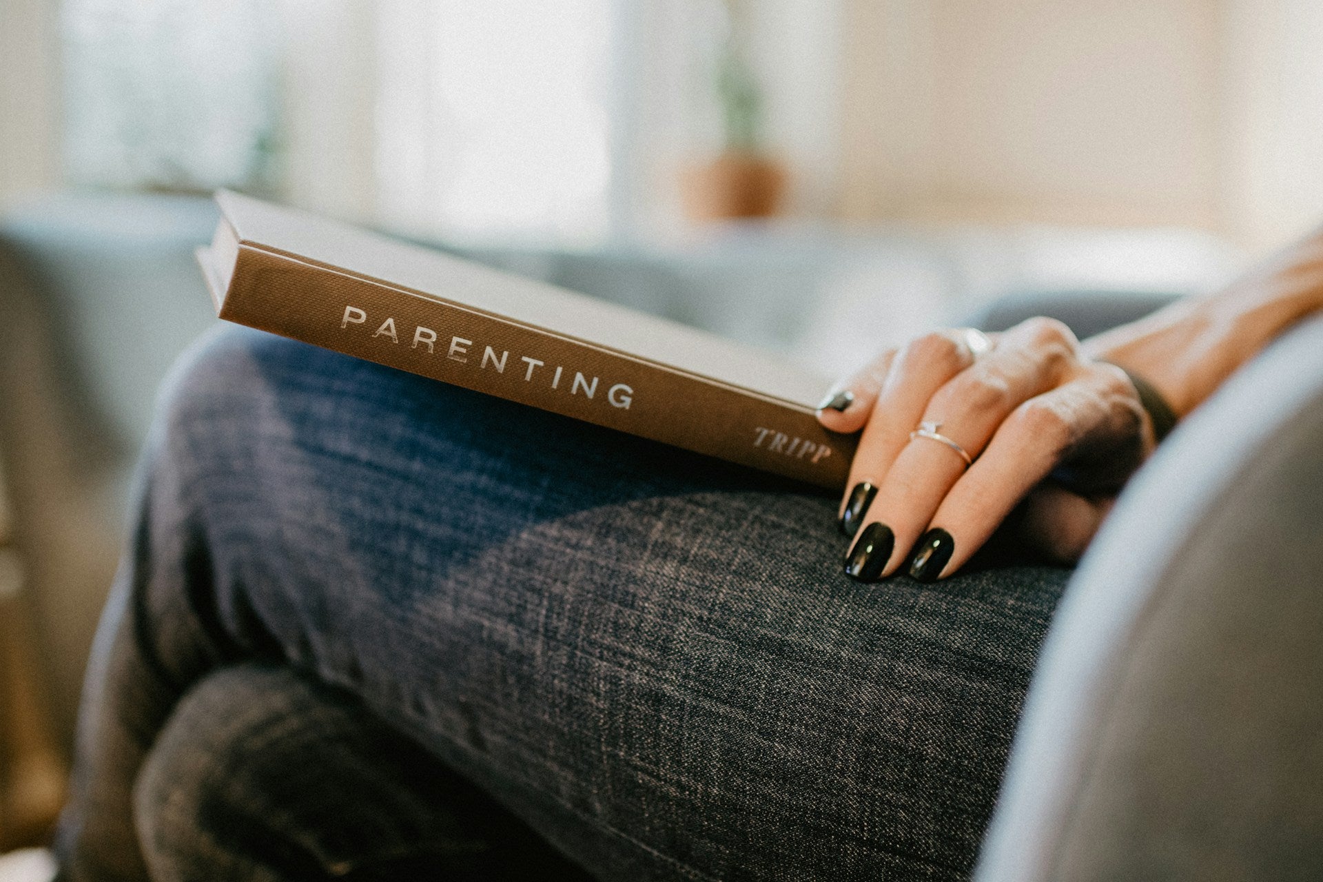 Women holding a parenting book on her lap
