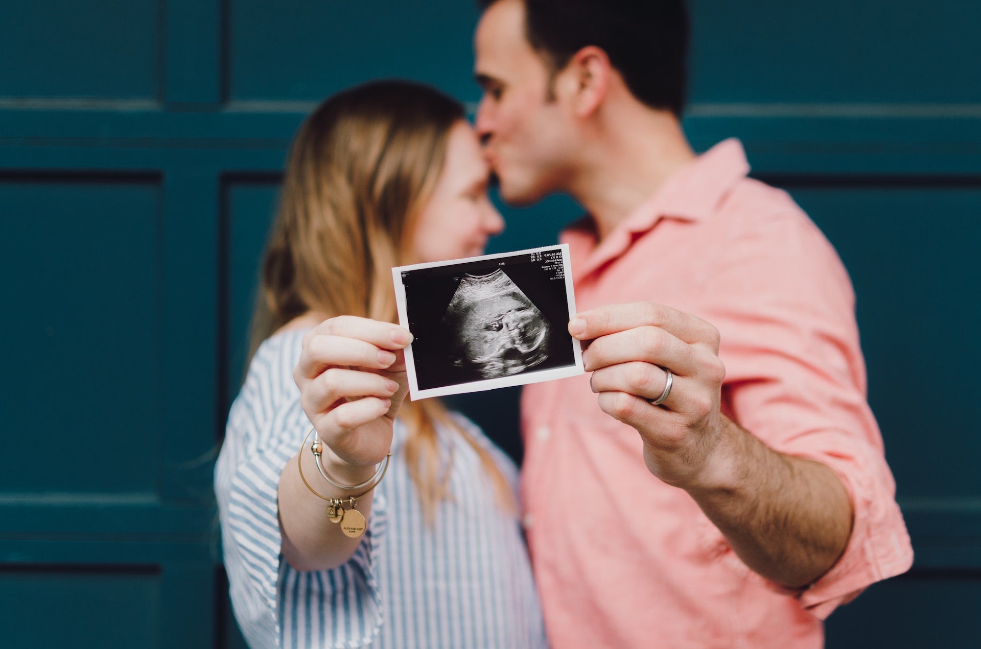 Happy couple holding an image of sonogram of baby 